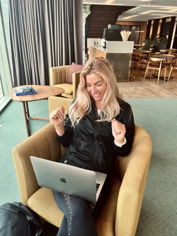 CiCi laughing while checking in with a client on her laptop